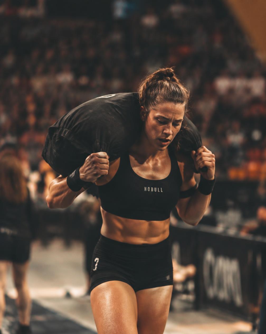Woman carrying a sandbag in a functional fitness race